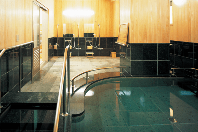 大浴槽は檜と天然石でできた特別空間